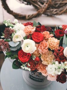 A beautifully arranged bouquet of colorful roses and carnations in a decorative vase.